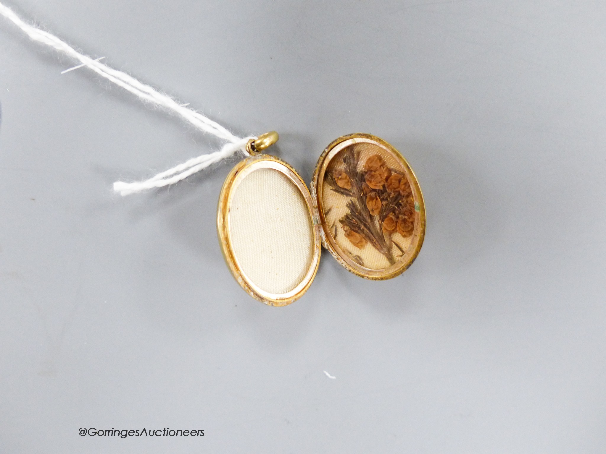 A George V 15ct oval locket, with engraved date, 24mm, gross 4 grams.